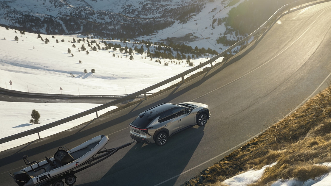 Toyota-bZ4X-boot-aanhanger-schuin-bovenaanzicht-achter-winters-berglandschap