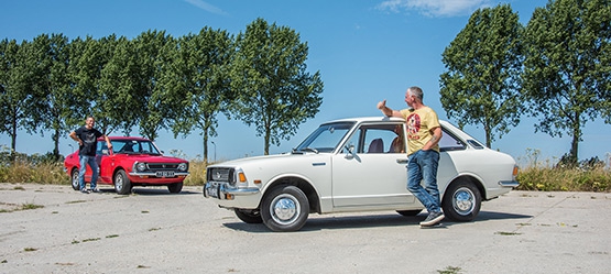 Toyota-Corolla-KE20-exterieur-zijkant-wit-driekwart-voor-rood-met-broers-voor-eigen-auto.jpg